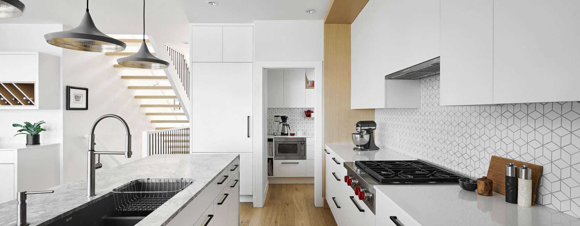 Sleek white modular kitchen layout with custom tile backsplash and kitchen island Bangalore